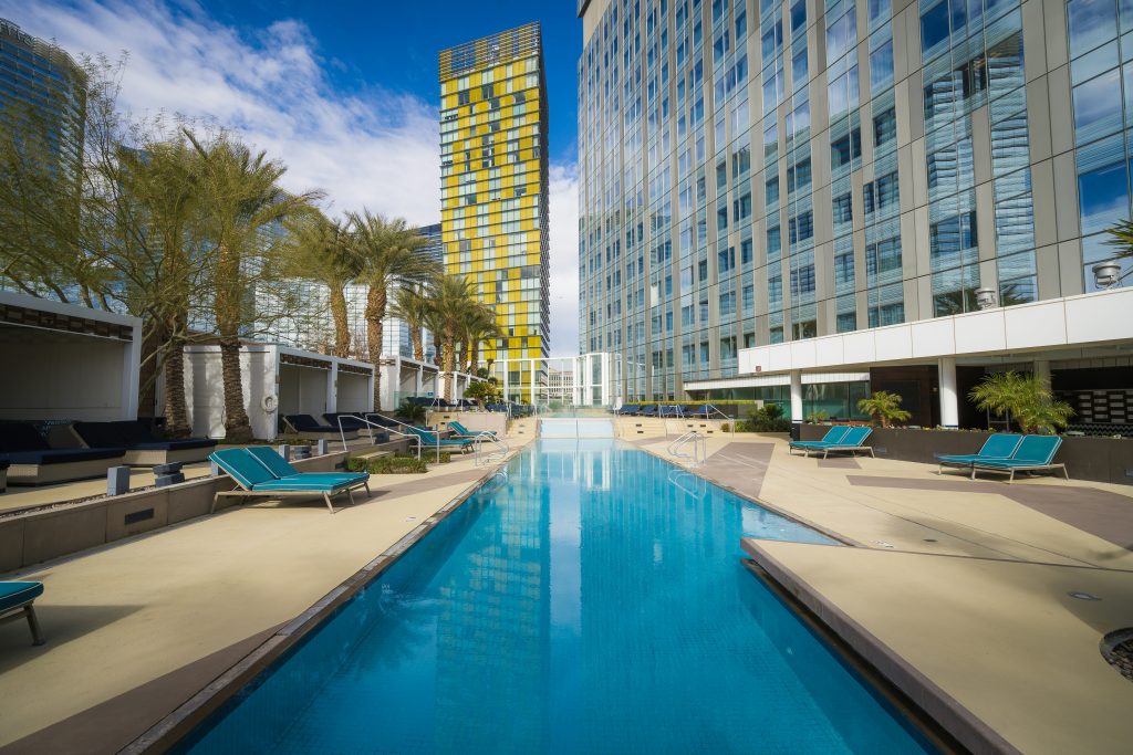 A pool next to a hotel on a summer day