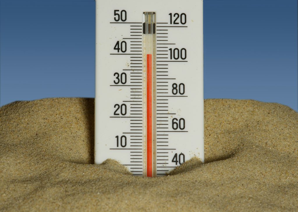 Thermometer in the sand showing a high heat index